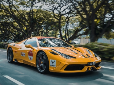 森の道を走るオレンジ色のスポーツカー